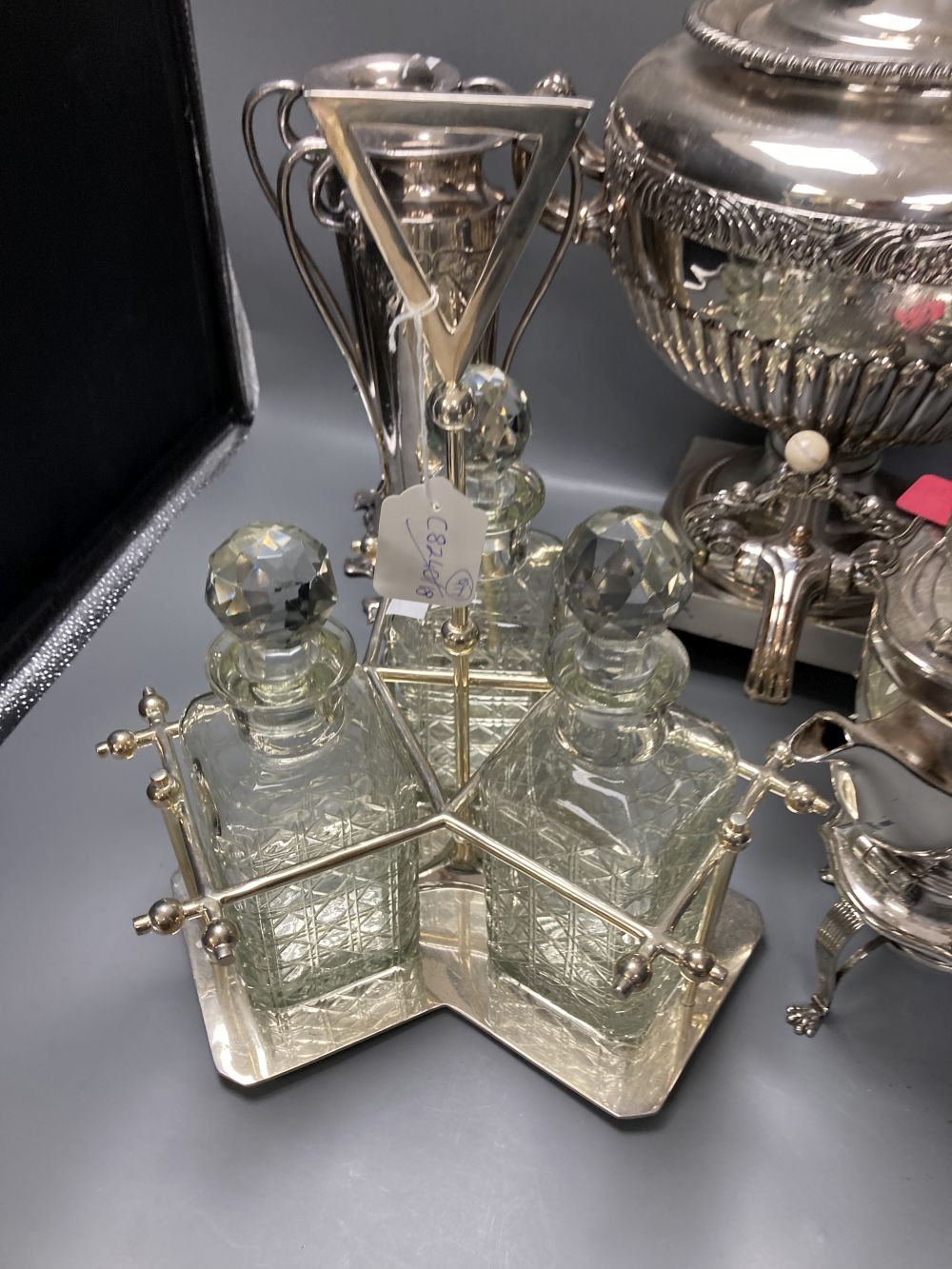 A plated samovar, a kettle on stand, a pair of vases and a three bottle silver plated tantalus and on Old Sheffield plate tea urn, c.18